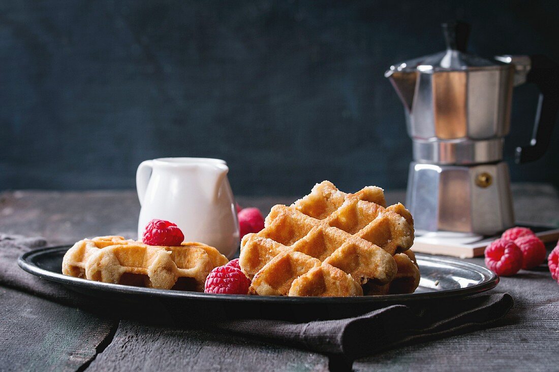 Belgian waffles with raspberries, served with coffee pot and jug of milk