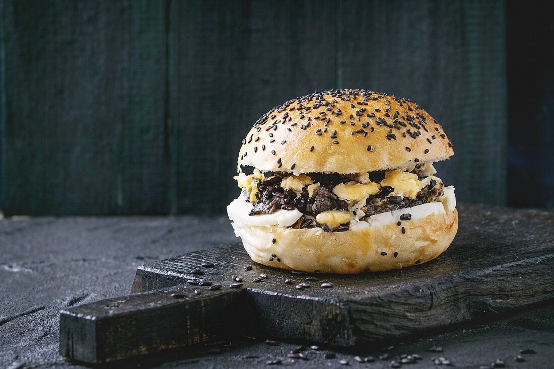 Homemade veggie burger with black rice, halloumi cheese and scrambled egg