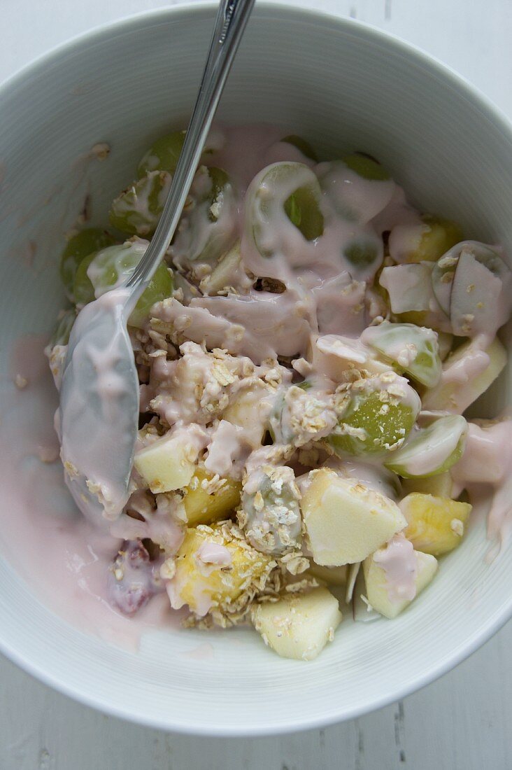 Müsli mit Haferflocken, Trauben, Mango, Äpfel, Kokosraspeln und Joghurt aus Kokosmilch