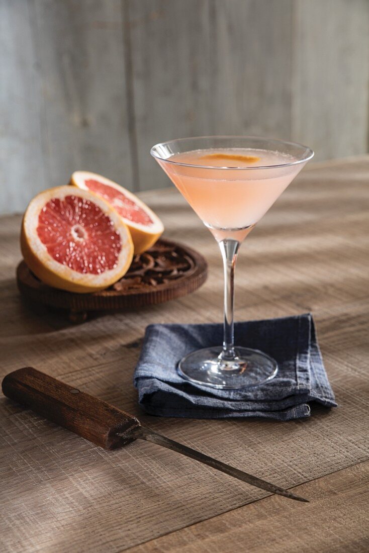 Champagne cocktail in Martini glass with ruby red pink grapefruit