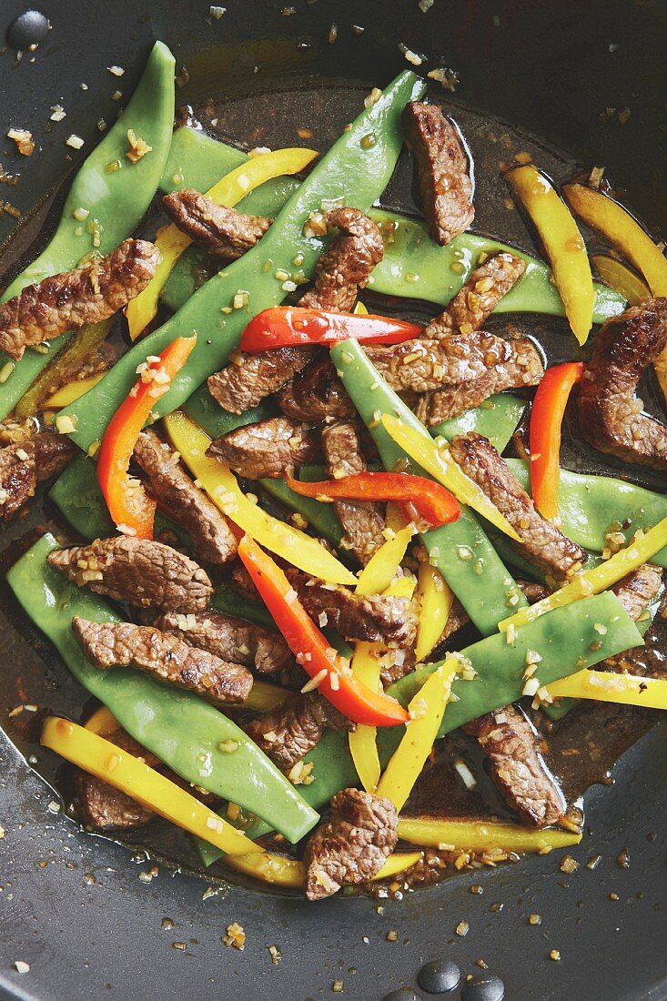 Flash-fried steak strips with colourful vegetables in the wok