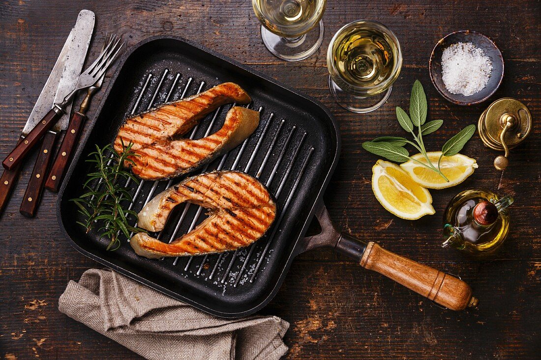 Grilled salmon Steak on grill pan on wooden background with wine