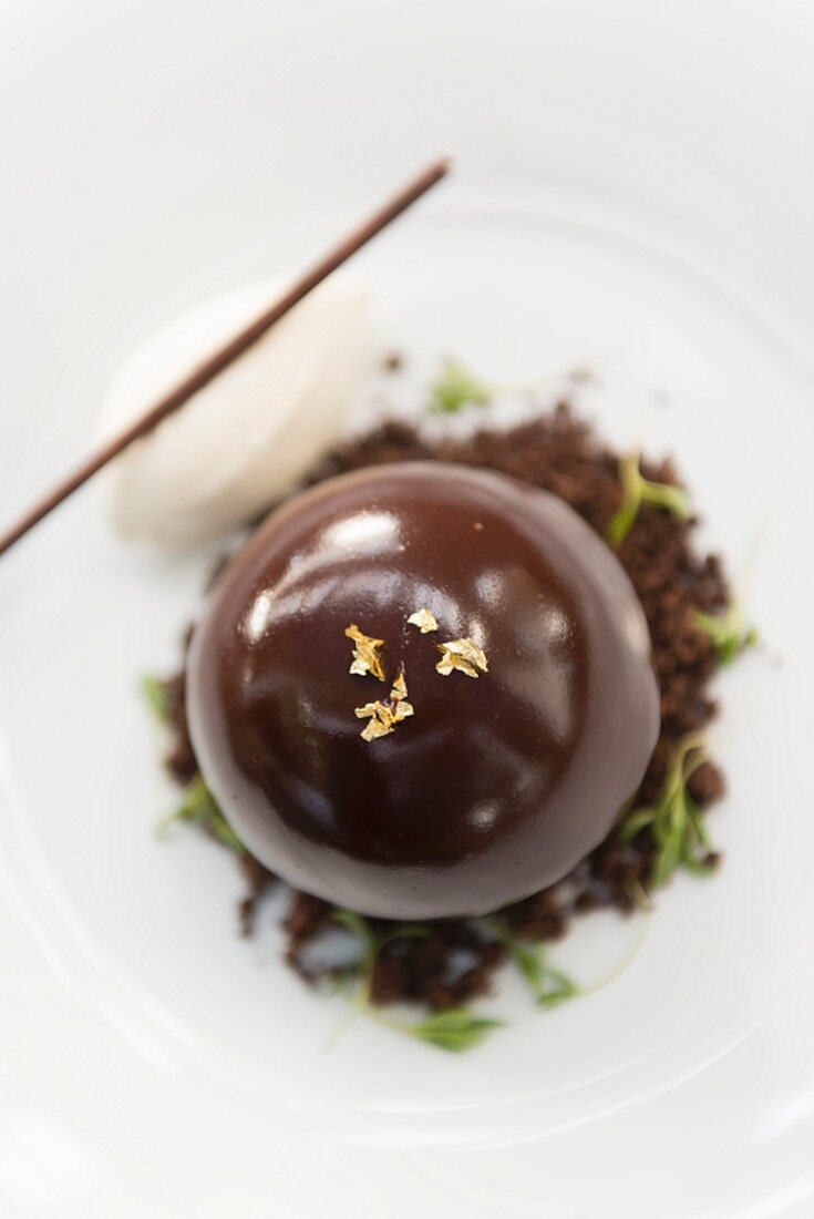 Chocolate bombe dessert served with vanilla ice cream