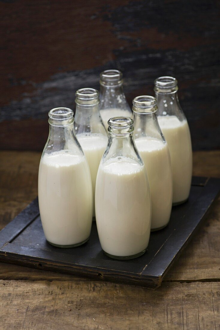 Milch in Flaschen auf Holzuntergrund
