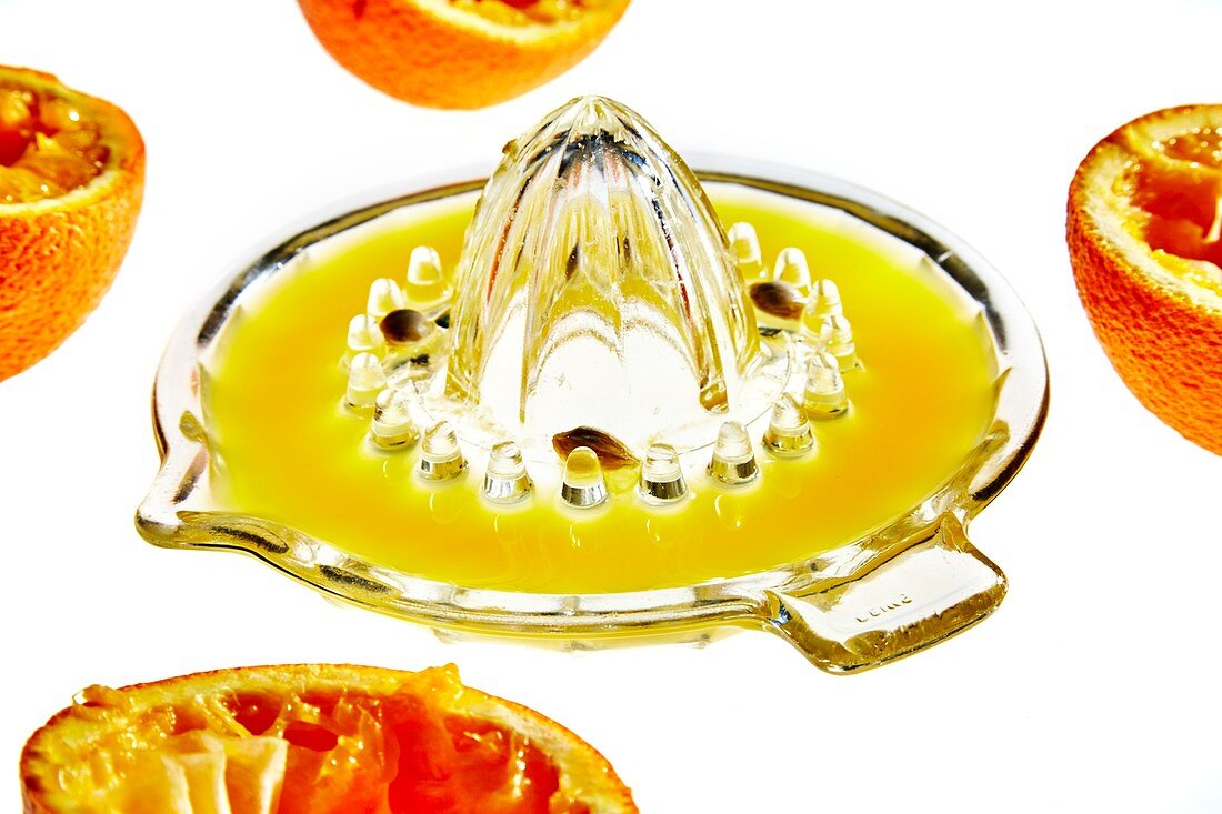 Orange halves and glass juicer