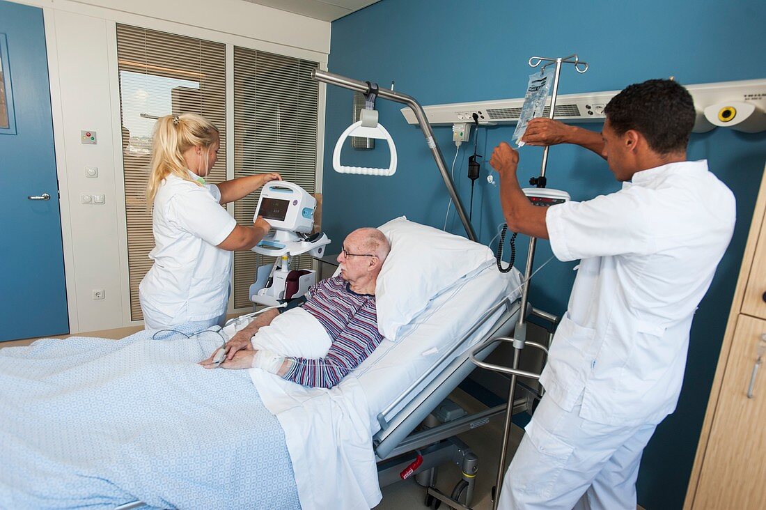 Nurses working with senior man