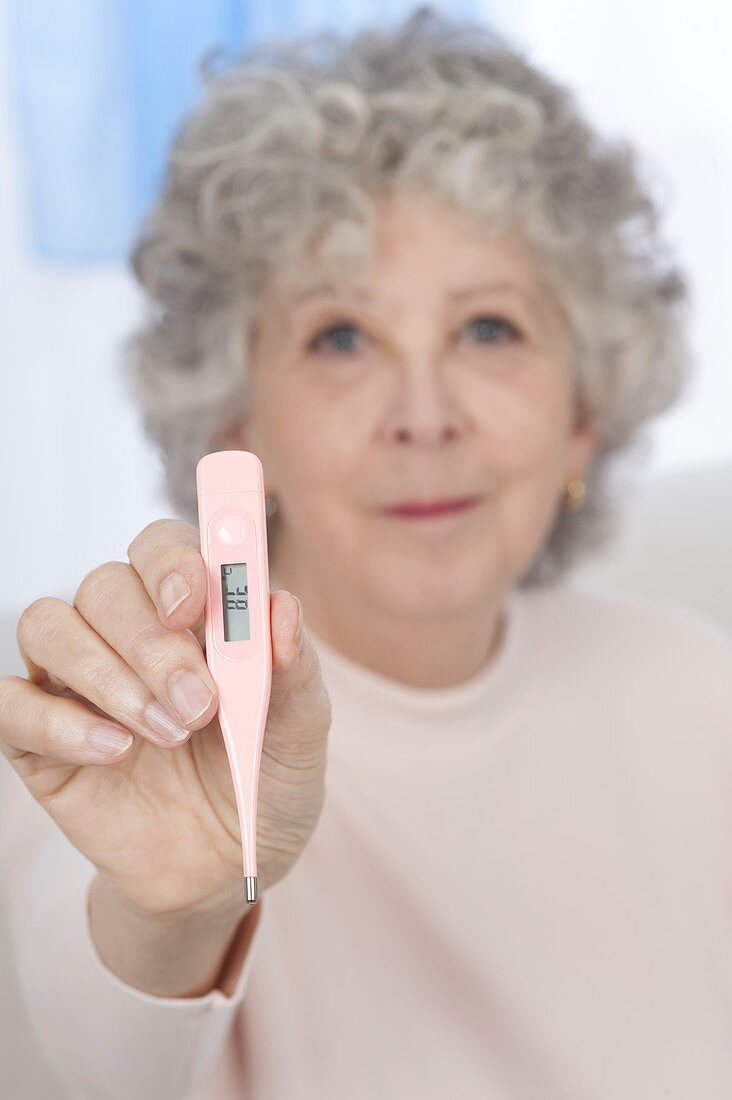 Woman holding digital thermometer