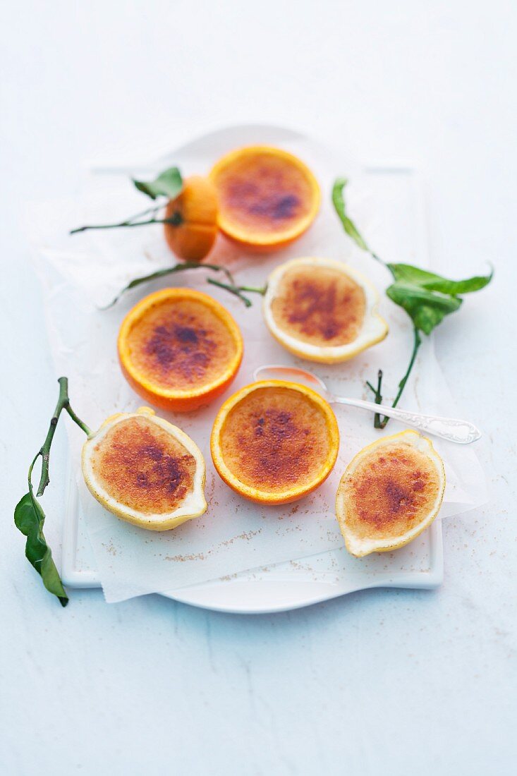 Crema Catalana serviert in ausgehöhlten Orangen- und Zitronenhälften