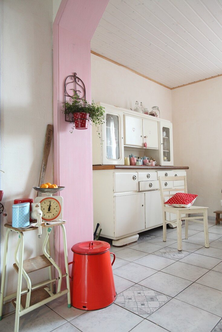 50s dresser and pink wood cladding on arch in corner of kitchen