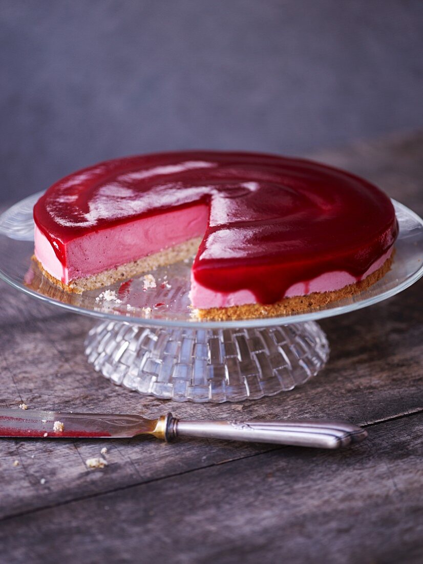 Cranberry and fresh cheese tart, sliced on a cake stand