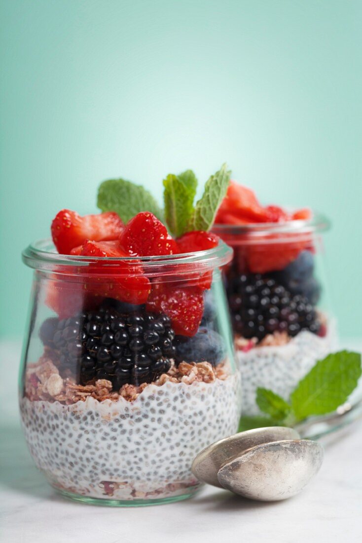 Chia seeds vanilla pudding and berries on blue background