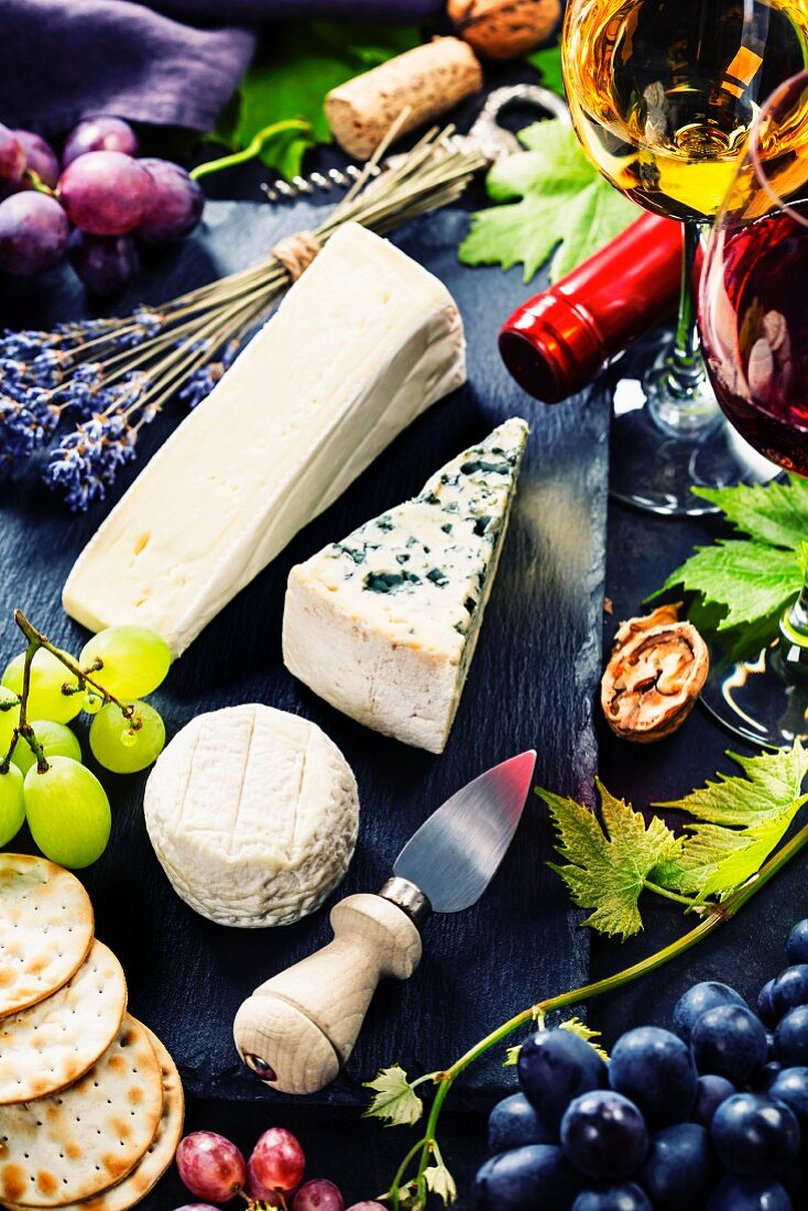 Käseplatte mit verschiedenen Käsesorten, Wein und Trauben