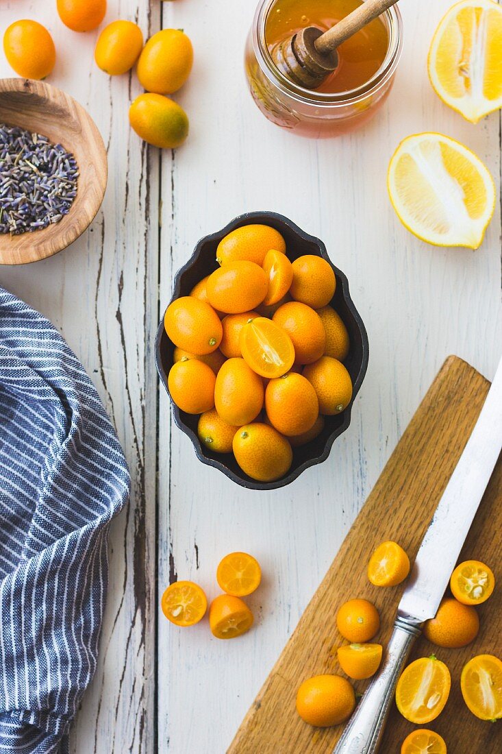 Stillleben mit Kumquats, Zitrone, Lavendel und Honig (Aufsicht)