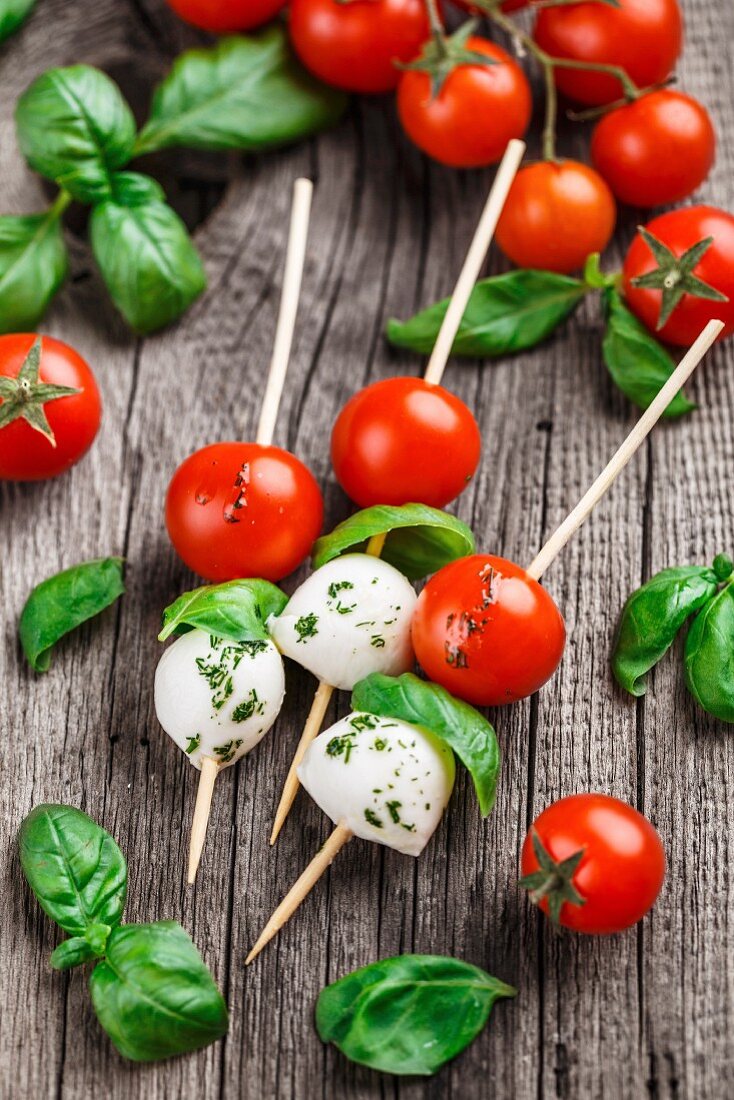 Skewers with tomato, basil and mozarella on a rustic background