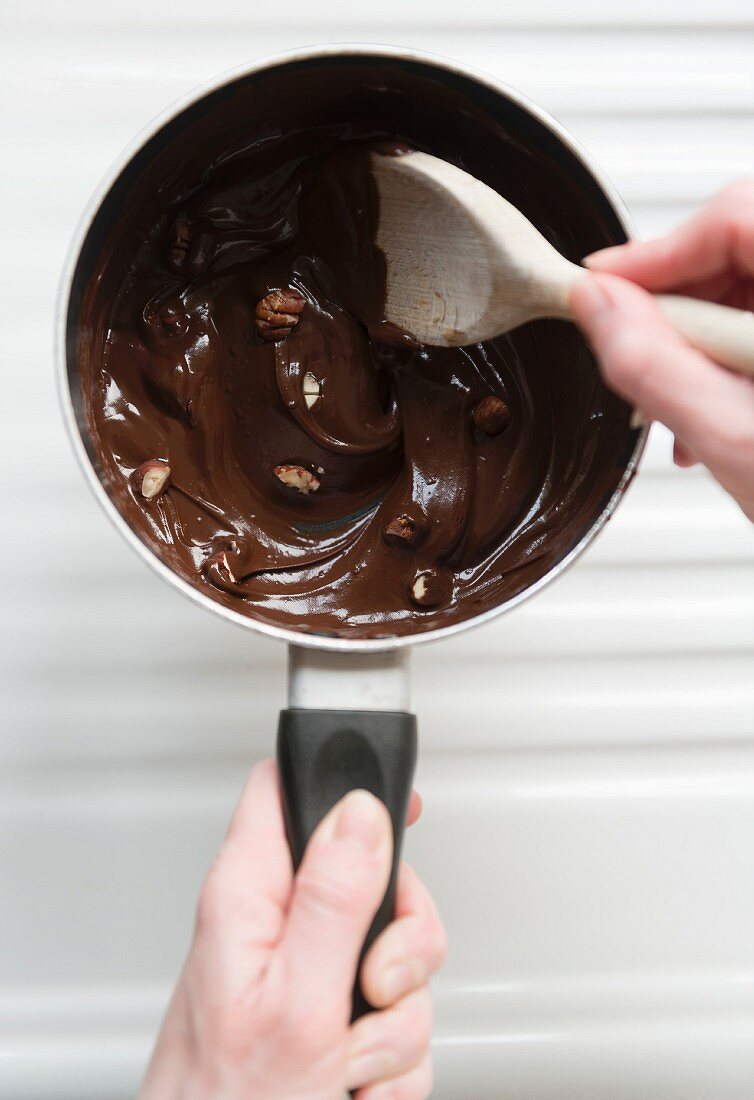 Geschmolzene Schokolade mit Nüssen in einem Topf