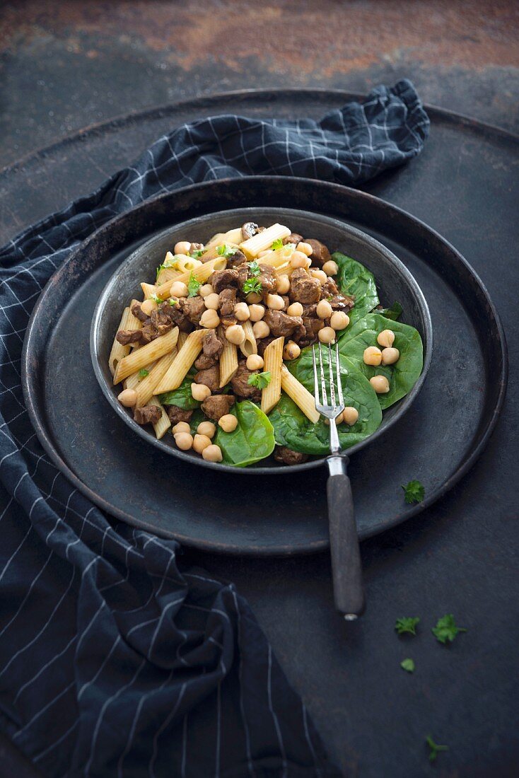 Vegan pasta with soya goulash, chickpeas and baby leaf spinach