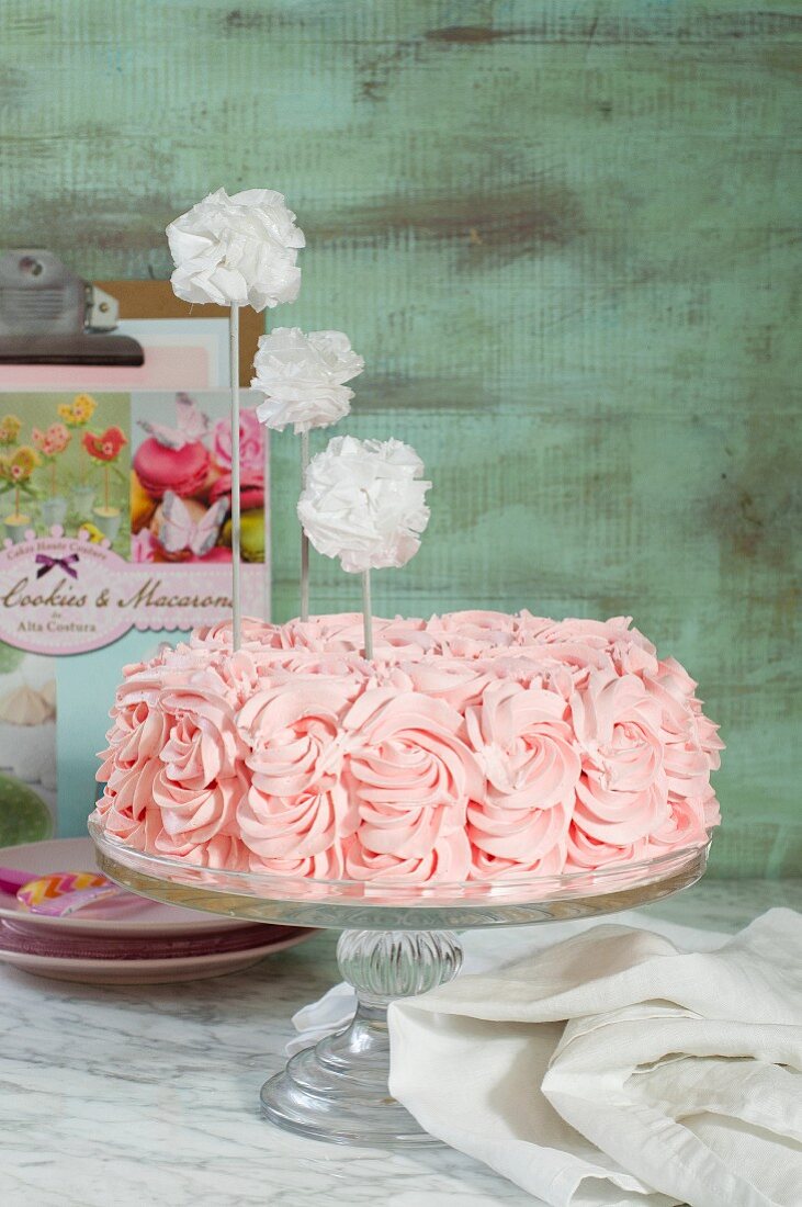 A pink birthday cake on a cake stand
