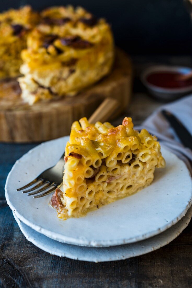 A slice of macaroni cheese cake on a plate