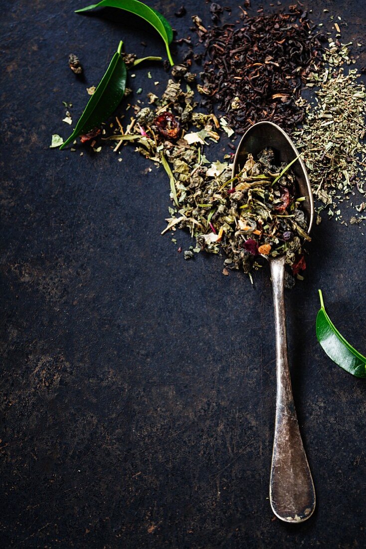 Tea composition with old spoon on dark background