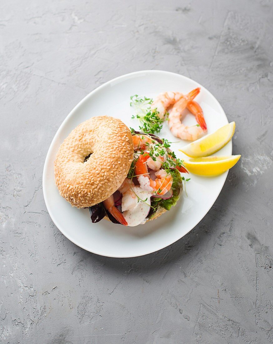 A bagel with prawns and radish