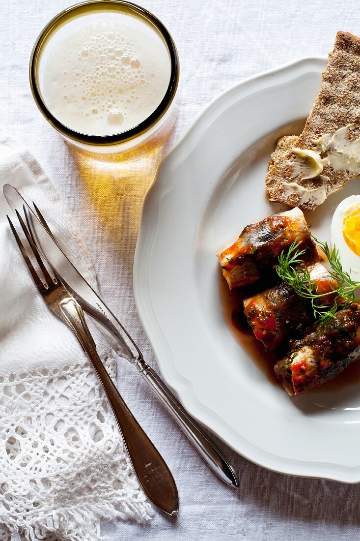 Herring rolls in tomato sauce with egg, crispbread and beer (Sweden)