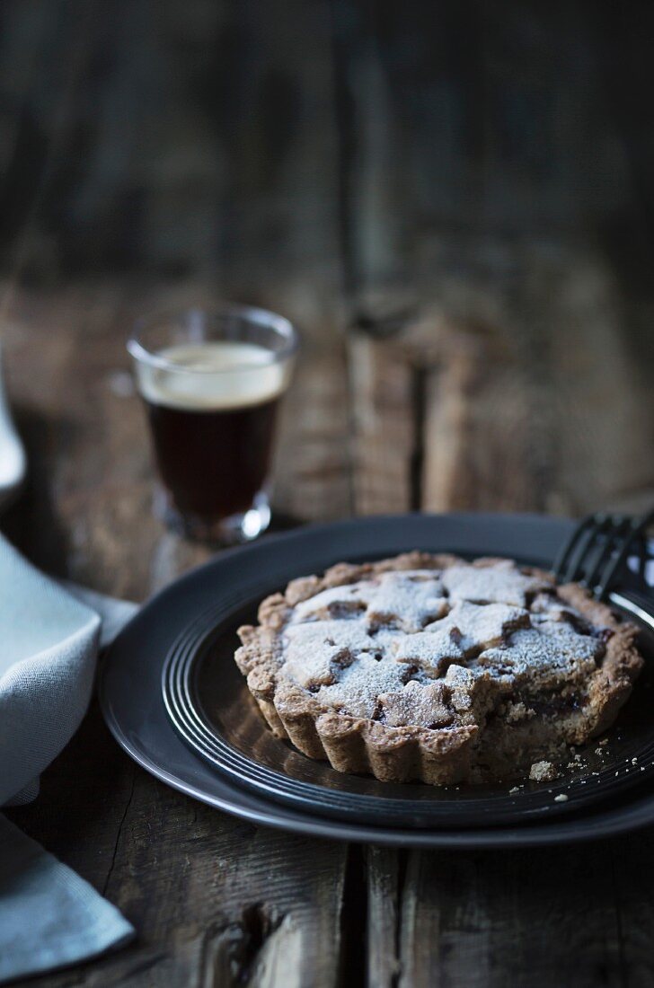 Tart with a glass of coffee on wooden table