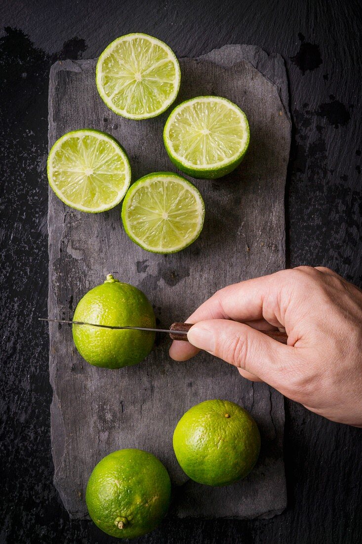 Hand cutting limes with a vintage knife on slate board