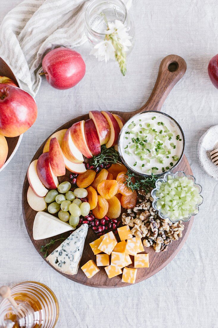 Käseplatte mit Früchten, Nüssen und Dip (Aufsicht)