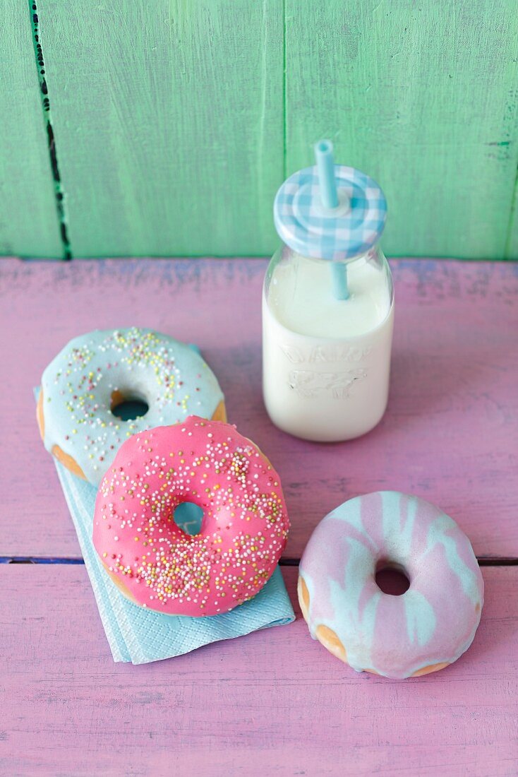 Doughnuts with a colorful sugar glaze and a milk bottle