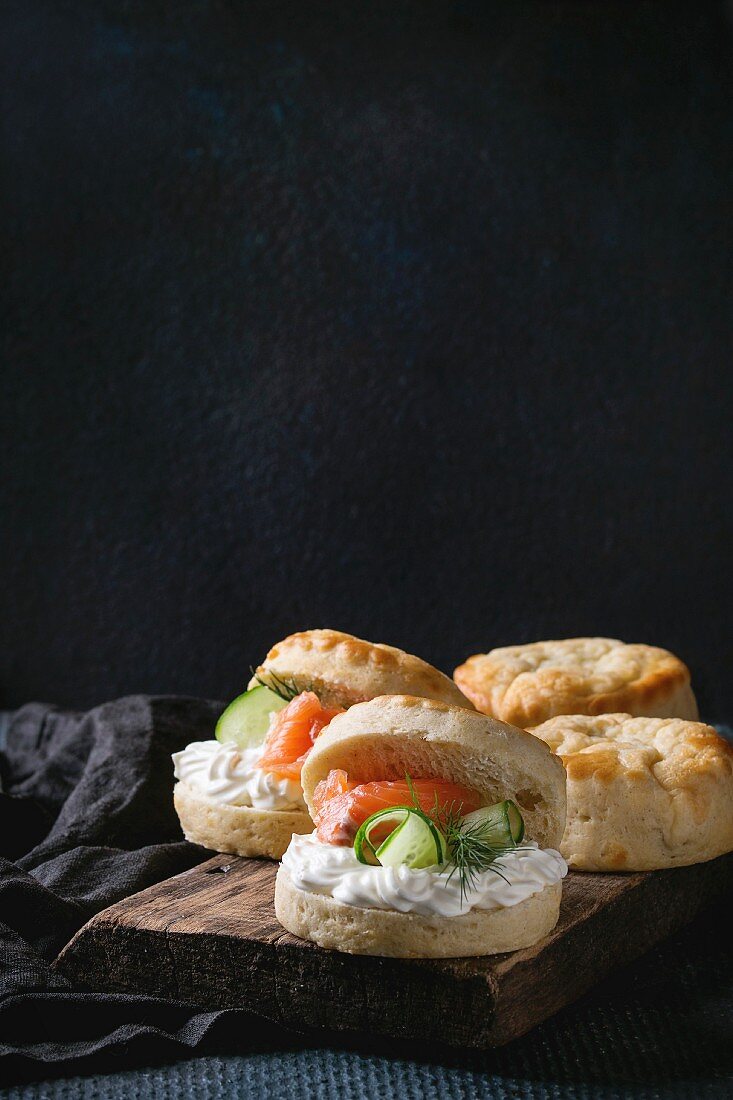 Sliced traditional english cheese scones with smoked salmon, creme cheese and fresh cucumber served with whole scones