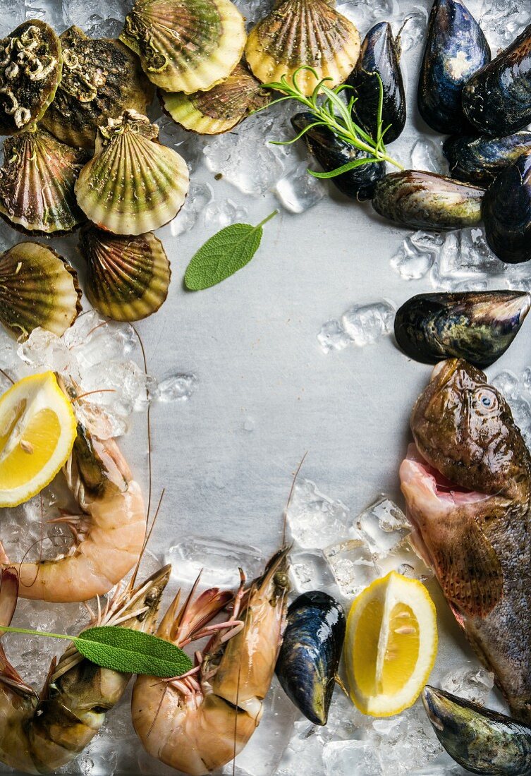 Fresh seafood with herbs and lemon on ice, prawns, fish, mussels and scallops