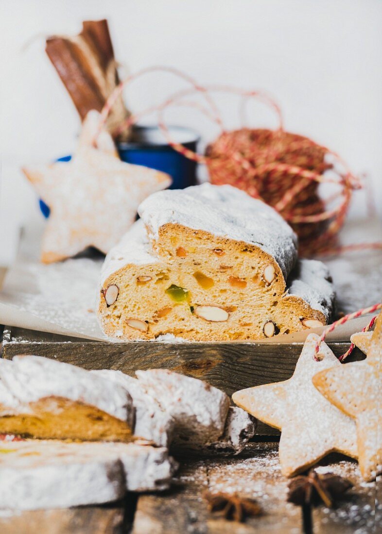 Piece of Traditional German Christmas cake Stollen with festive gingerbread star shaped cookies