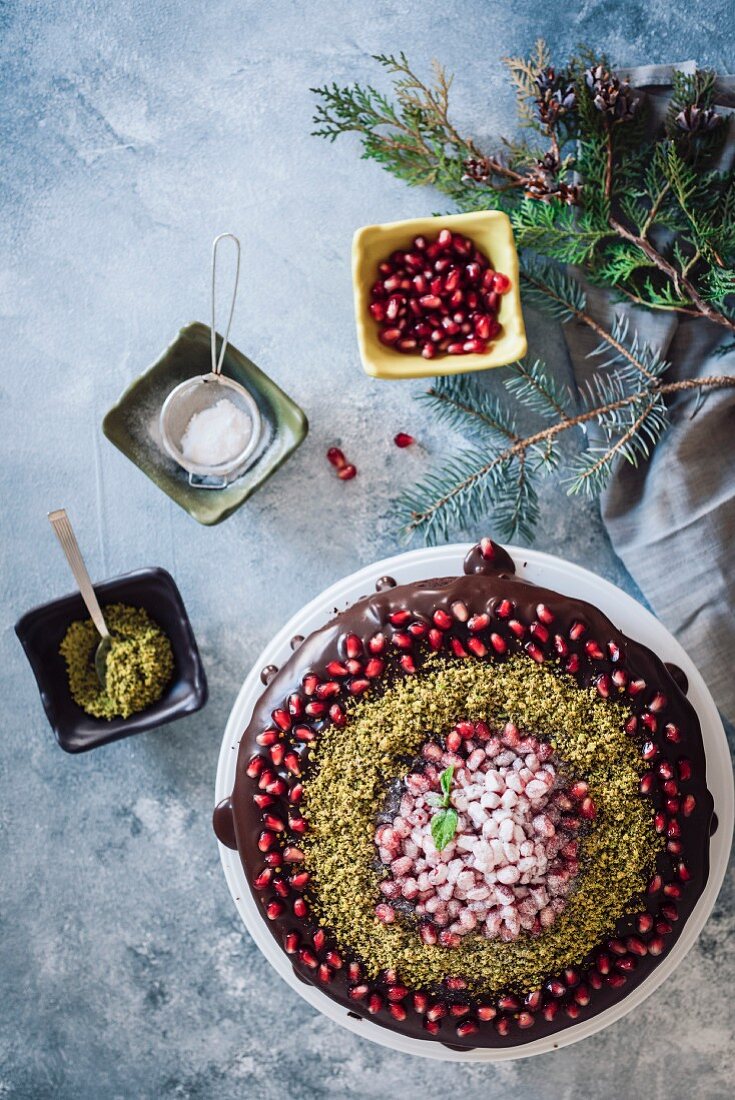 Christmas chocolate cake decorated with pomegranate seeds and pistachio