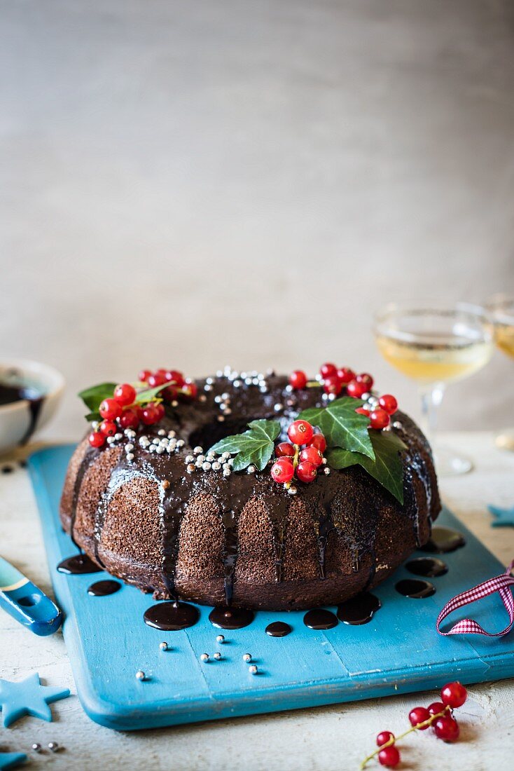 Chocolate bundt cake with chocolate sauce and red currants