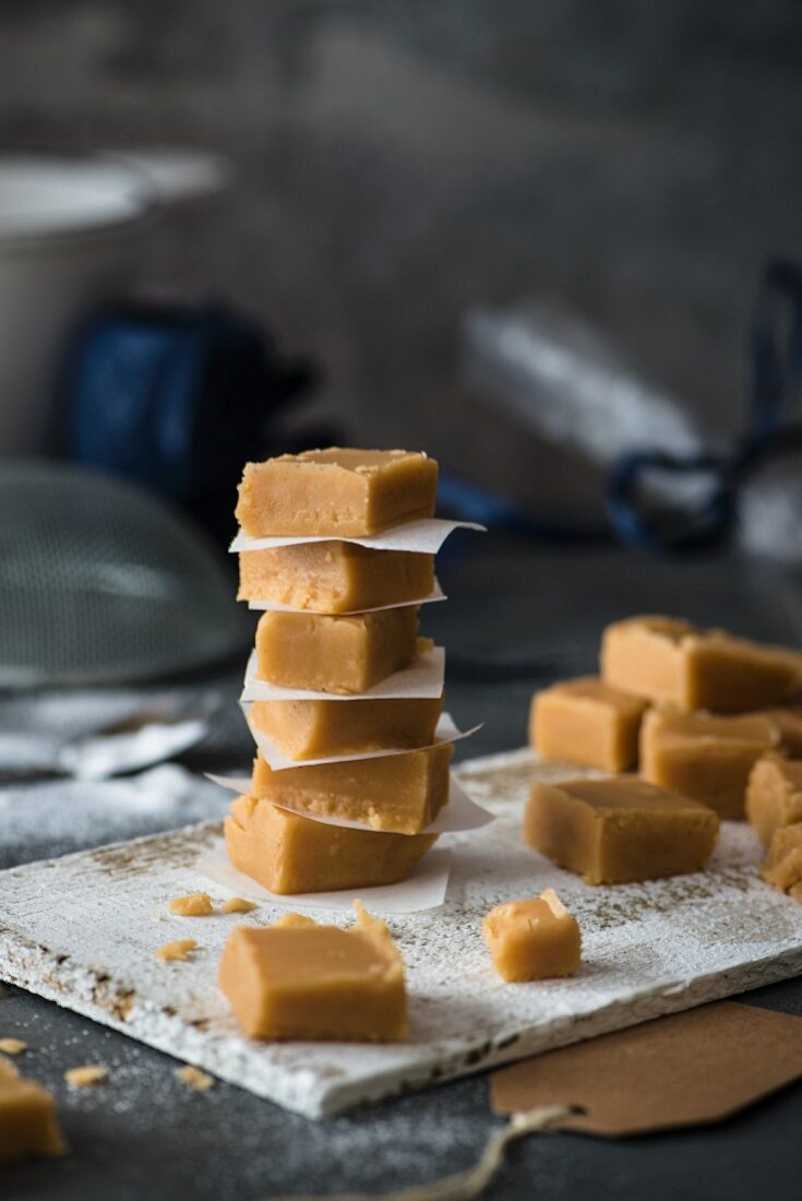 Hausgemachter Vanilla Fudge in Würfeln auf Holzbrettchen
