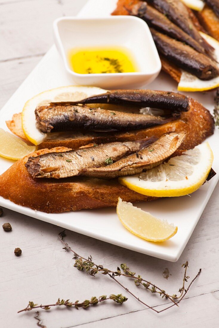 Spanische Tapas: Sprotten mit Zitrone auf Röstbrot