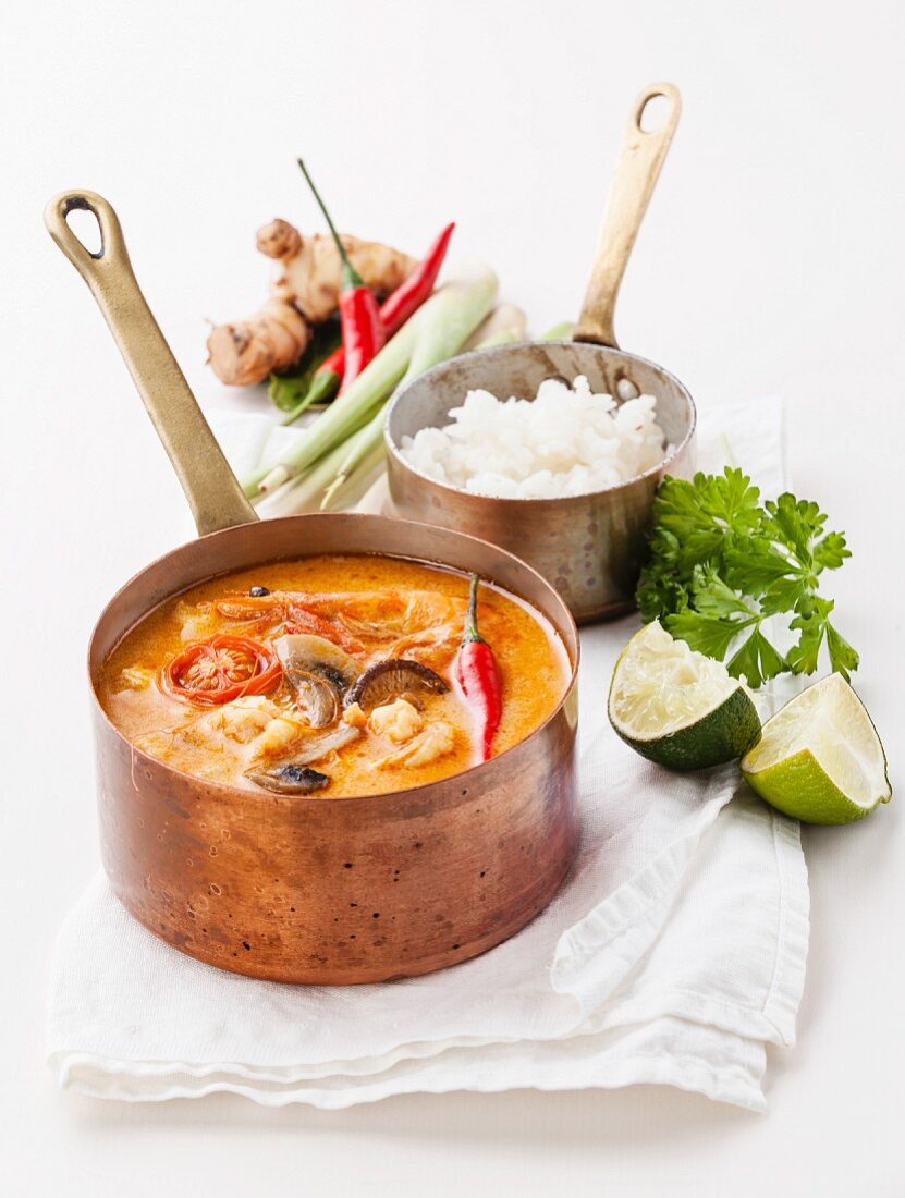 Spicy Thai soup Tom Yam with Rice, Chili pepper and Seafood on white background