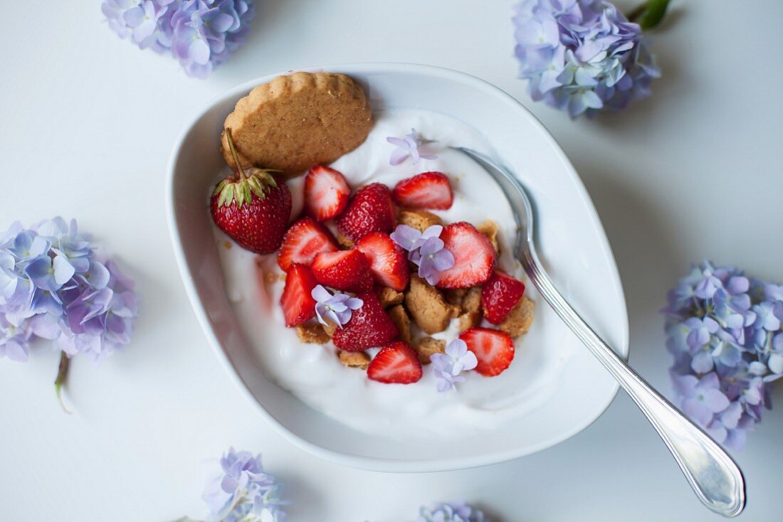 Coconut yogurt with strawberries and crushed coconut cookies