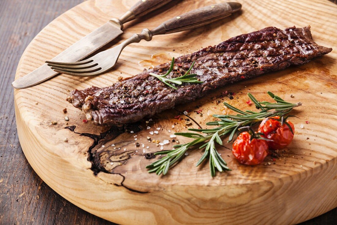 Steak-Machete mit Rosmarin, Salz und Pfeffer auf Holzplatte