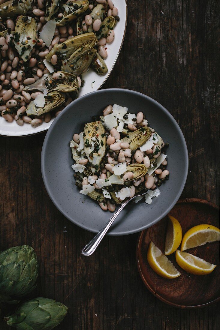 A bowl of braised baby artichoke salad with white beans and shaved manchego