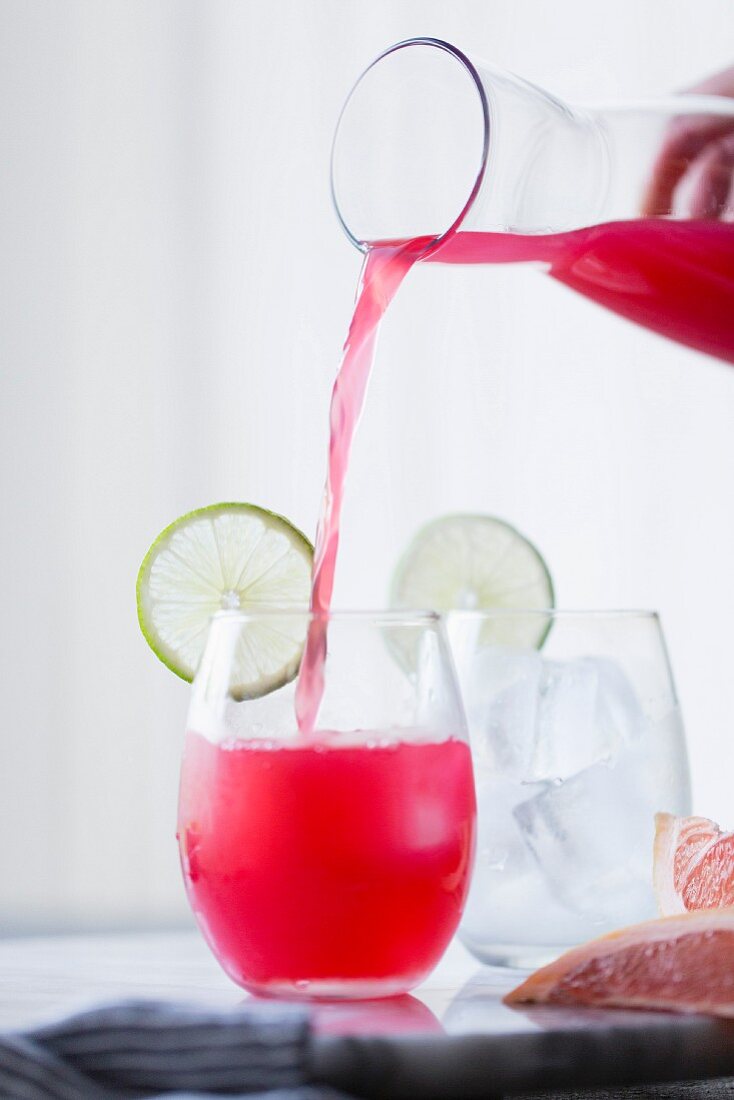 Hibiscus-Paloma mit Ingwer (Cocktail mit Tequilla) wird in Glas gegossen