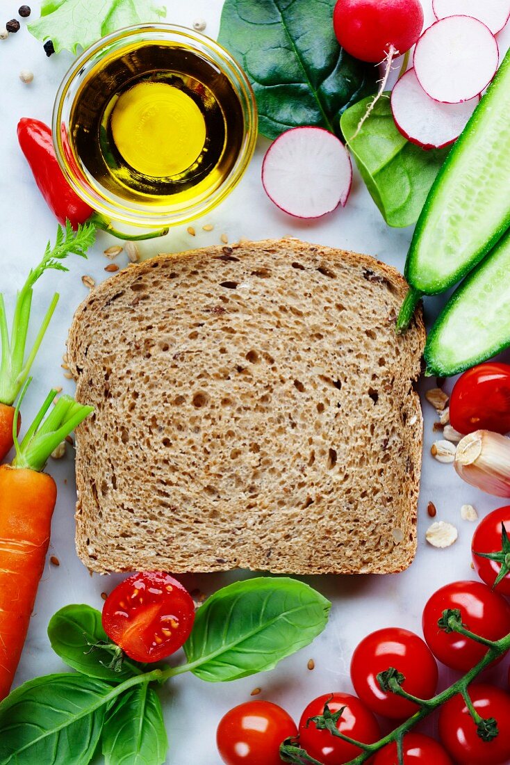 Slice of a whole wheat bread and healthy organic vegetables for making sandwiches