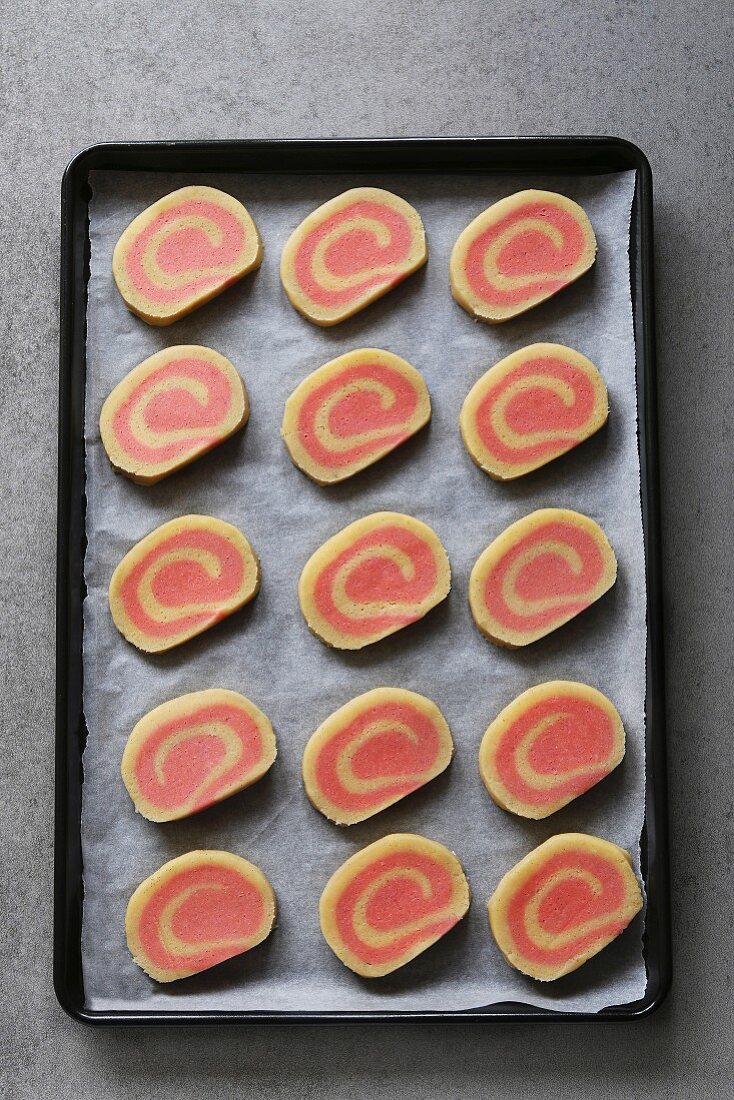 Ungebackene rosa Pinwheel Cookies mit Erdbeer-Vanillegeschmack auf Backblech
