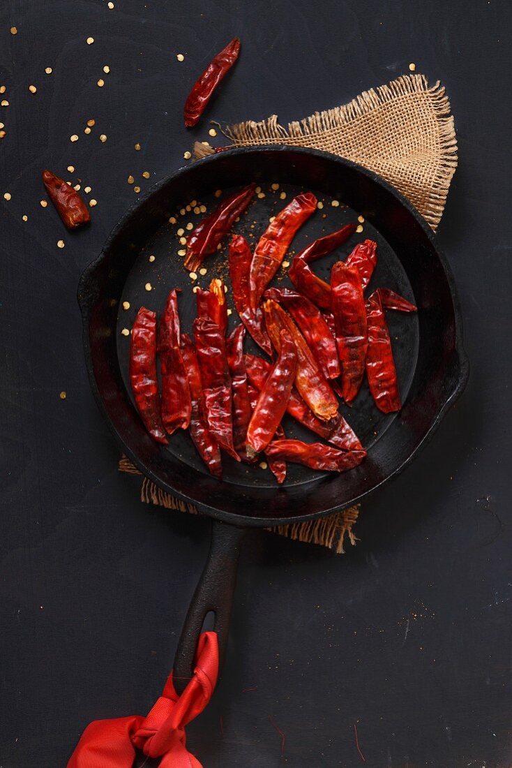 Getrocknete rote Chilischoten in gusseiserner Pfanne (Aufsicht)