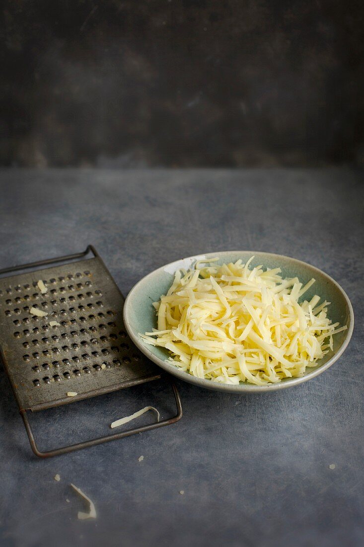 Ceramic Bowl of Shredded Cheese with Vintage Cheese Grater