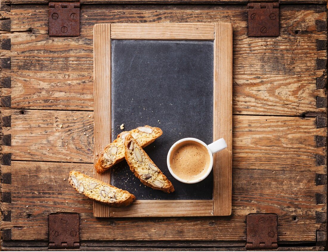 Coffee cup and biscotti on vintage slate chalk board