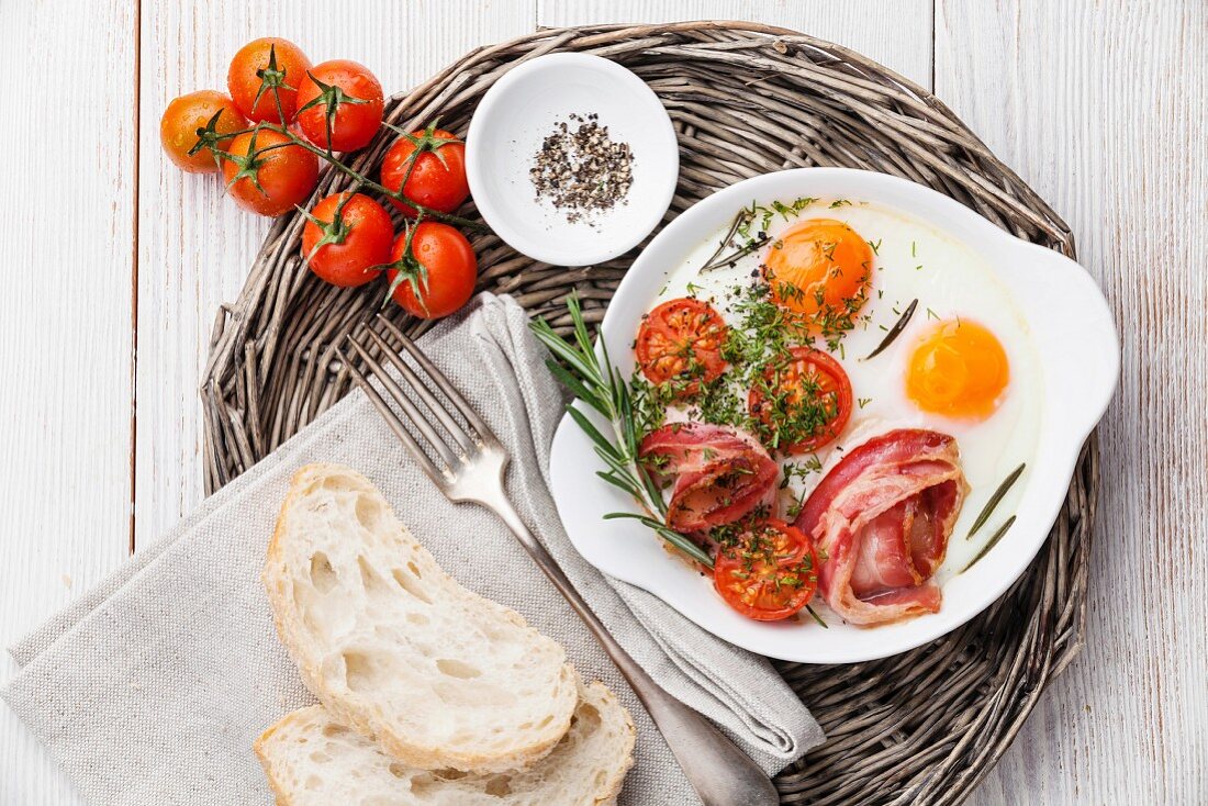 Frühstück mit Spiegeleiern, Tomaten und Speck