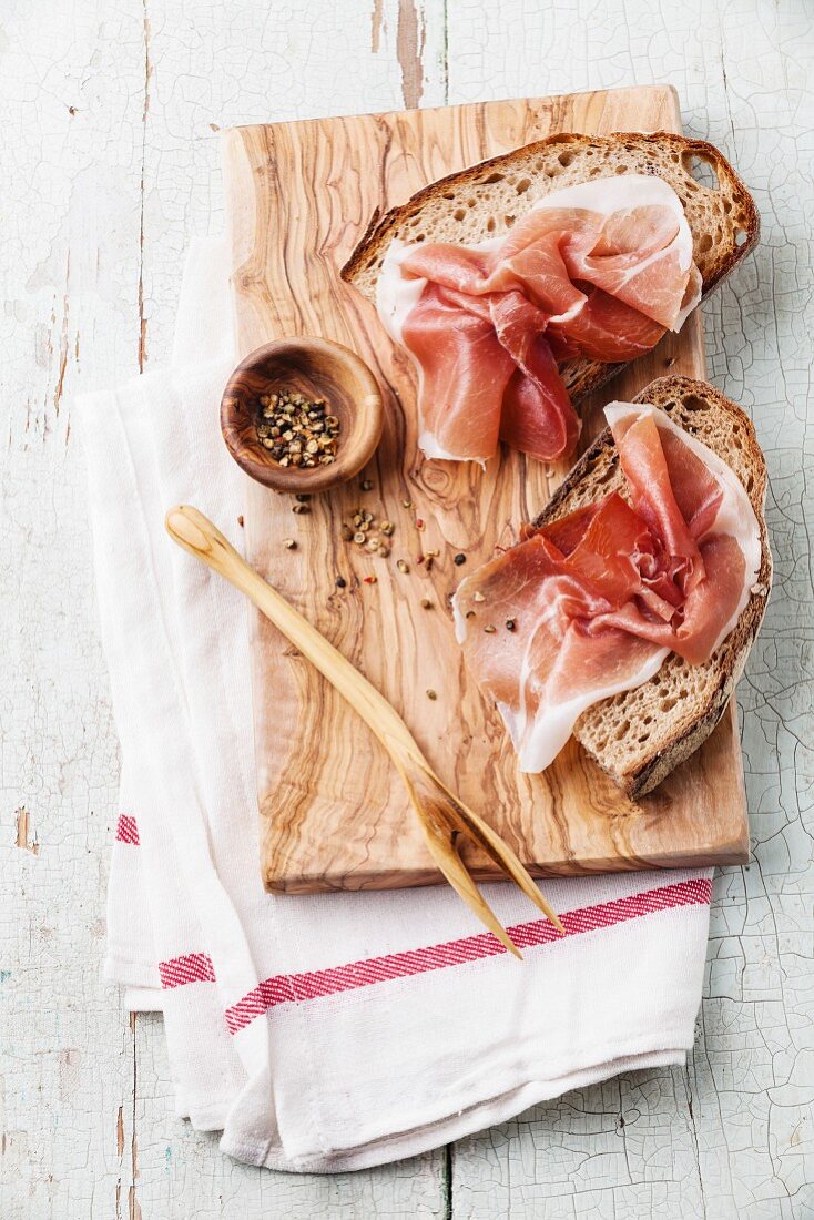 Bruschettas with ham on bread on blue wooden background