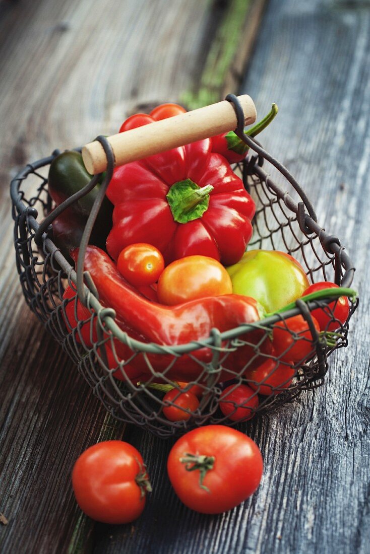 Rote Paprikaschoten und Tomaten in einem Korb