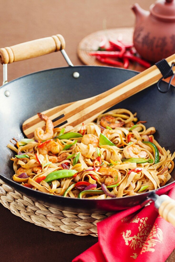 Asian stir fried noodle with vegetabled and prawns in wok